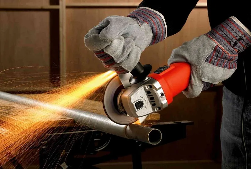 Người thợ đang sử dụng máy cắt cầm tay với đầy đủ trang bị bảo hộ, nhấn mạnh tầm quan trọng của an toàn lao động trong gia công cơ khí