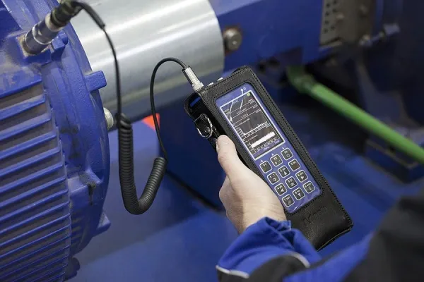 Chuyên gia đang sử dụng máy đo độ rung để kiểm tra máy móc công nghiệp, áp dụng cách sử dụng máy đo độ rung vào bảo trì dự đoán.