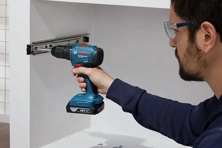 Thợ cơ khí sử dụng máy khoan pin để bắt vít vào bề mặt gỗ, minh họa allintitle:máy khoan có bắt vít được không trong công việc thực tế