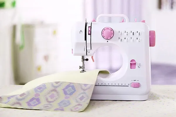 Máy may mini gia đình màu trắng với thiết kế nhỏ gọn, sẵn sàng cho người dùng học cách sử dụng máy may mini gia đình, tạo ra những sản phẩm thủ công tinh xảo.