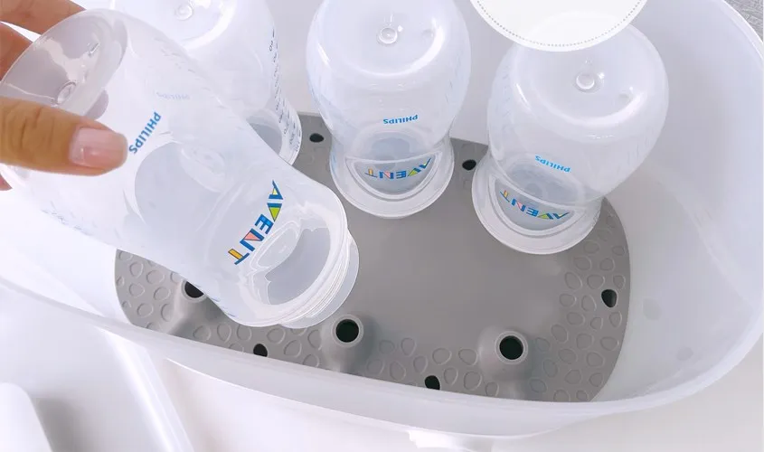 Xếp các bình sữa và dụng cụ cần tiệt trùng vào máy tiệt trùng bình sữa Avent một cách khoa học.