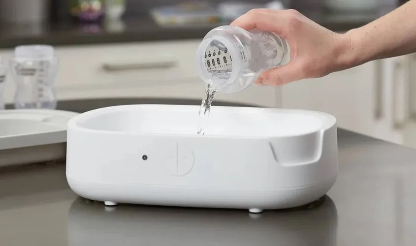 Đổ đúng lượng nước 100ml vào máy tiệt trùng bình sữa Avent để đảm bảo hiệu quả.