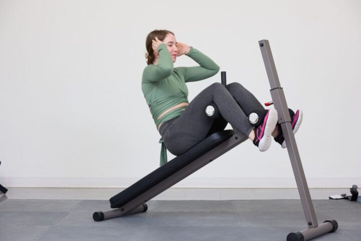 Người phụ nữ tập luyện trên máy tập cơ bụng để giảm mỡ hiệu quả