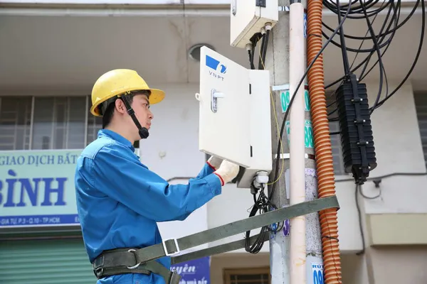 Kỹ thuật viên hỗ trợ lắp đặt đường truyền cáp quang cho hệ thống wifi tại nhà