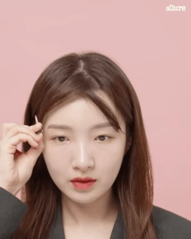 Chải lại tóc mái bằng lược tròn sau khi tạo kiểu để mái cong đều