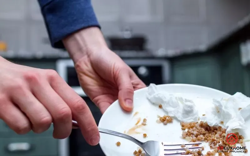 Gạt hết thức ăn thừa trên bát đĩa trước khi cho vào máy