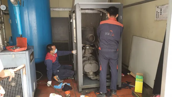 Thợ chuyên nghiệp tháo lắp chi tiết để sửa chữa máy nén khí trục vít
