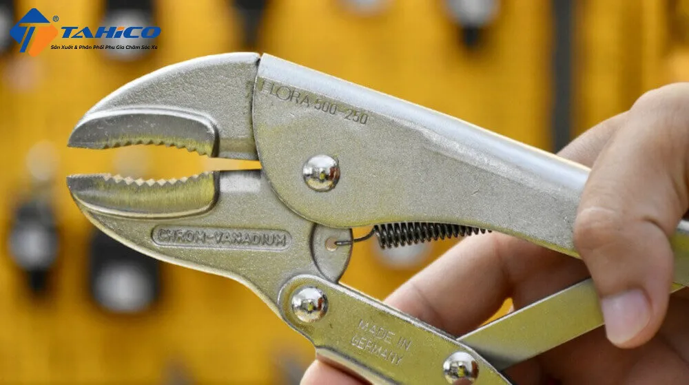 Người đang cố gắng tăng độ bám để vặn ốc vít bị toét đầu bằng cách sử dụng một miếng cao su.