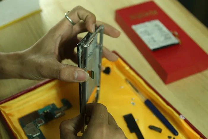 Nhẹ nhàng dùng móng tay bẩy nhẹ các góc và tháo rời cụm màn hình, bàn phím khỏi khung máy Blackberry Passport