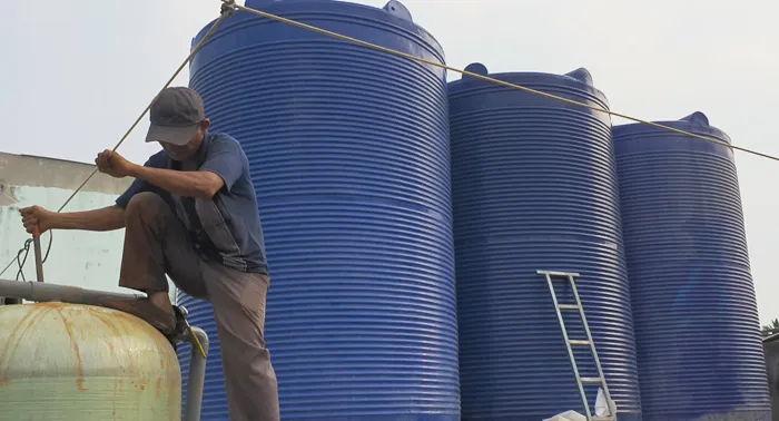 Kỹ thuật viên đang thay thế vật liệu lọc cho cột lọc nước giếng khoan nhiễm phèn