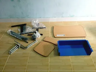 Các bộ phận rời của bàn học tự lắp bao gồm mặt bàn, ngăn bàn và ống thép