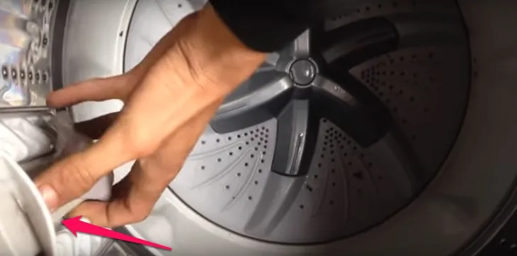 Thao tác tháo túi lọc cũ khỏi máy giặt một cách nhẹ nhàng