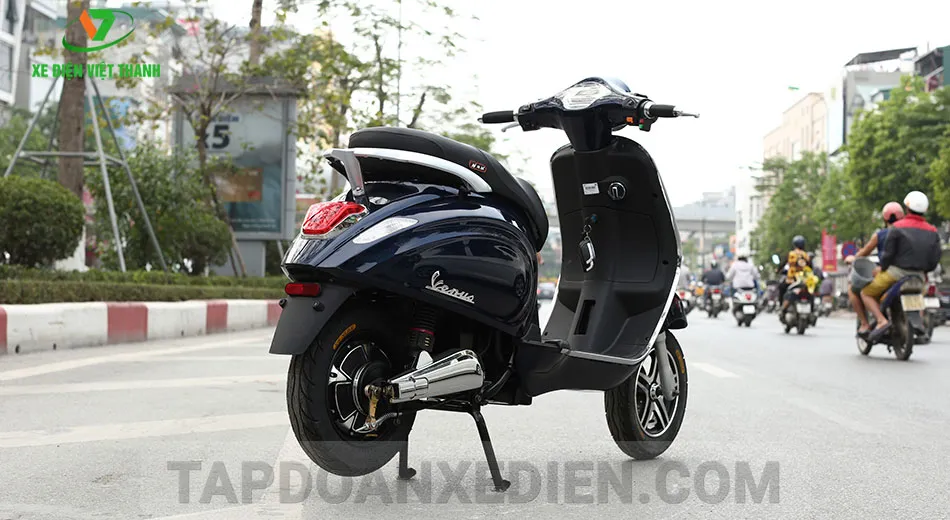 Một người đang kiểm tra lốp xe máy điện Vespa Venus, thể hiện quy trình bảo dưỡng xe máy điện Vespa định kỳ để duy trì hiệu suất tốt nhất.