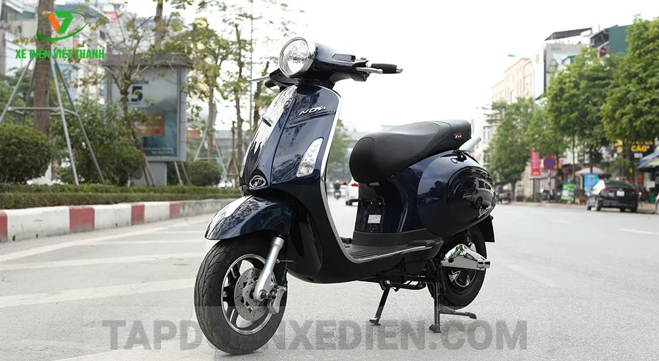 Toàn cảnh xe máy điện Vespa Venus màu trắng đang sạc pin, nhấn mạnh tầm quan trọng của việc sạc pin xe máy điện Vespa đúng cách để kéo dài tuổi thọ ắc quy.