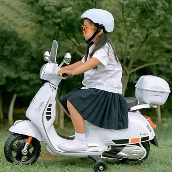 Xe máy điện trẻ em Vespa, bé đội mũ bảo hiểm khi lái xe để đảm bảo an toàn