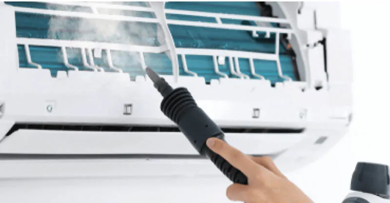 Vệ sinh tấm lưới lọc không khí của máy lạnh Toshiba bằng vòi xịt nước mạnh để loại bỏ bụi bẩn